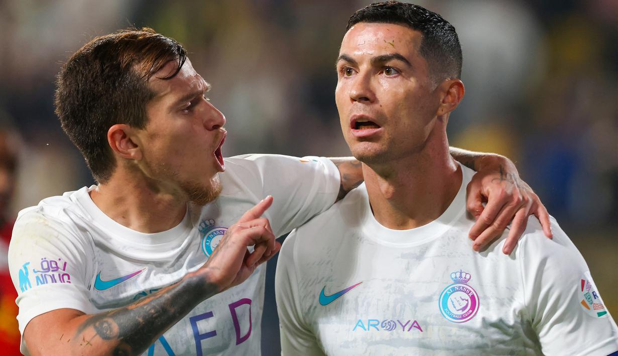 Selebrasi pemain Al Nassr, Otavio (kiri), setelah mencetak gol ke gawang Al Riyadh berkat umpan yang diberikan oleh Cristiano Ronaldo dalam laga pekan ke-16 Saudi Pro League 2023/2024 yang digelar di Al Awwal Park, Sabtu (9/12/2023) dini hari WIB. (AFP/Fayez Nureldine)