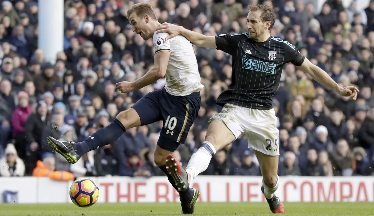 Pemain Tottenham Hotspur, Harry Kane (kiri) melepaskan tembakan saat dihadang pemain West Brom, Craig Dawson pada laga Premier League di White Hart Lane stadium, London, (14/1/2017).  (AP/Matt Dunham)