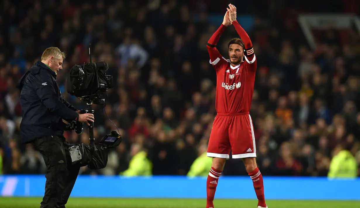 Gelandang Great Britain & Ireland XI, David Beckham, memberikan aplaus usai bertanding pada laga amal melawan World XI di Old Trafford, Inggris, Sabtu (14/11/2015) dini hari WIB. (AFP Photo/Paul Ellis)