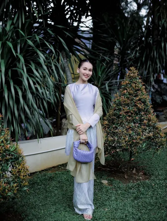 Dalam sebuah pertemuan keluarga, Ayu Ting Ting memancarkan pesona keanggunan mengenakan baju kurung warna lilac. Baju kurungnya ia padukan bersama selendang warna soft yellow dan hand bag warna senada dengan baju yang dikenakannya. [@Instagram/ayutingting92].