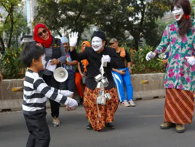 Seniman pantomim dari Dewan Kesehatan Rakyat melakukan aksi teatrikal di CFD kawasan Senayan, Jakarta, Minggu (30/07). Mereka meminta semua pihak lindungi anak dari makanan dan minuman yang buruk. (Liputan6.com/Fery Pradolo)
