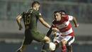 Bek Madura United, Jaimerson Silva, berebut bola dengan pemain Tira Persikabo pada laga Shopee Liga 1 di Stadion Pakansari, Bogor (12/7). Tira bermain imbang 2-2 atas Madura. (Bola.com/Yoppy Renato)