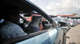 Sopir taksi saat menunggu antrean mengisi BBG di SPBG Pemuda, Jakarta, Kamis (15/11). Minimnya keberadaan SPBG menyebabkan antrean panjang kendaraan yang akan mengisi BBG hingga ke pinggir jalan menimbulkan kemacetan. (Merdeka.com/Iqbal S. Nugroho)