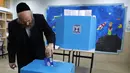 Pria Yahudi ultra-Ortodoks memberikan suaranya selama pemilihan parlemen Israel di Yerusalem (9/4). Warga Israel hari ini memberikan suara dalam pemilihan tingkat tinggi yang akan memutuskan masa jabatan PM Benjamin Netanyahu meskipun ada dugaan korupsi yang dilakukannya. (AFP Photo/Menahem Kahana)