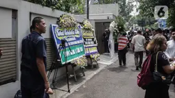 Karangan bunga ucapan duka cita atas meninggalnya almarhum Ashraf Sinclair di kawasan Pejaten Barat IV, Jakarta, Selasa (18/2/2020). Ashraf Sinclair dinyatakan meninggal oleh dokter di Rumah Sakit MMC Kuningan, Jakarta Selatan pukul 04.51 WIB. (Liputan6.com/Faizal Fanani)