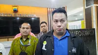 Salah satu peserta yang menjadi korban dugaan pengeroyokan di Munas Hipmi XVII, Muhammad Aaron Annar Sampetoding didampingi kuasa hukumnya usai menjalani pemeriksaan di Polresta Solo, Selasa (22/11).(Liputan6.com/Fajar Abrori)