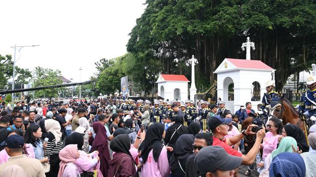 Masyarakat menyaksikan Satuan Pasukan Pengamanan Presiden (Paspampres) RI menggelar Upacara Serah Terima Pengawal Istana Kepresidenan di depan Istana Merdeka, Jakarta. (Setpres)