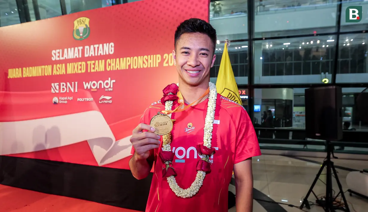 Pemain bulu tangkis Indonesia, Dejan Ferdiansyah berpose dengan memegang medali kemenangan Badminton Asia Mixed Team Championships saat acara penyambutan di Terminal 3 Bandara Soekarno Hatta, Tangerang, Senin (17/02/2025). (Bola.com/Bagaskara Lazuardi)