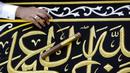 Pekerja menyulam kaligrafi Islam menggunakan benang berlapis emas pada tahap akhir pembuatan Kiswah Kabah di pabrik Kiswah di Mekah, Arab Saudi, Rabu (14/7/2021). Kiswah yang menutupi Kabah diganti setiap tahun untuk umrah atau haji. (AP Photo/Amr Nabil)