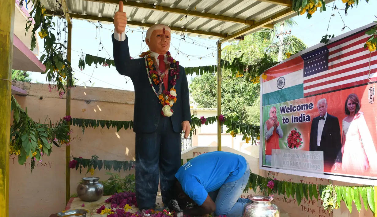 Bussa Krishna (33) melakukan penyembahan di depan patung Presiden AS Donald Trump di Desa Konney, Telangana, negara bagian India selatan (14/2/2020). Patung itu Bussa buat karena kekagumannya dengan sosok pemimpin Negeri Paman Sam tersebut. (AFP/Noah Seelam)