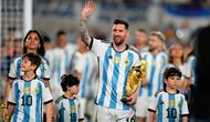 Lionel Messi berjalan ditemani Antonela Roccuzzo dan anak-anak mereka dengan membawa trofi Piala Dunia sambil menyapa para penonton. (AP Photo/Natacha Pisarenko)
