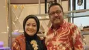 Kebaya kurung warna hitam dengan taburan beads putih, tampak kian elegan dipadukan dengan selendang merah dan bros emas. [@dewiranokarno].