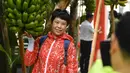 Seorang wisatawan berfoto di samping pohon pisang di rumah kaca buah-buahan tropis di Wanchang, Wilayah Yongji, yang terletak di Kota Jilin, Provinsi Jilin, China timur laut (12/8/2020). (Xinhua/Xu Chang)
