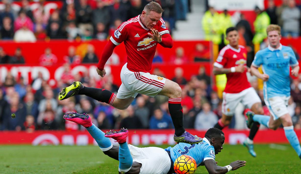 Pemain Manchester City, Bacary Sagna (bawah), berebut bola dengan pemain Manchester United, Wayne Rooney, dalam lanjutan Liga Premier Inggris di Stadion Old Trafford, Inggris, Minggu (25/10/2015). (Reuters/Eddie Keogh)