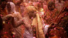 Para janda menari dan saling melempar serbuk berwarna dan kembang saat mengikuti tradisi perayaan Holi di Vrindavan, Uttar Pradesh, India (21/3). Holi merupakan salah satu festival perayaan awal musim semi terbesar di India. (REUTERS/Anindito Mukherjee)