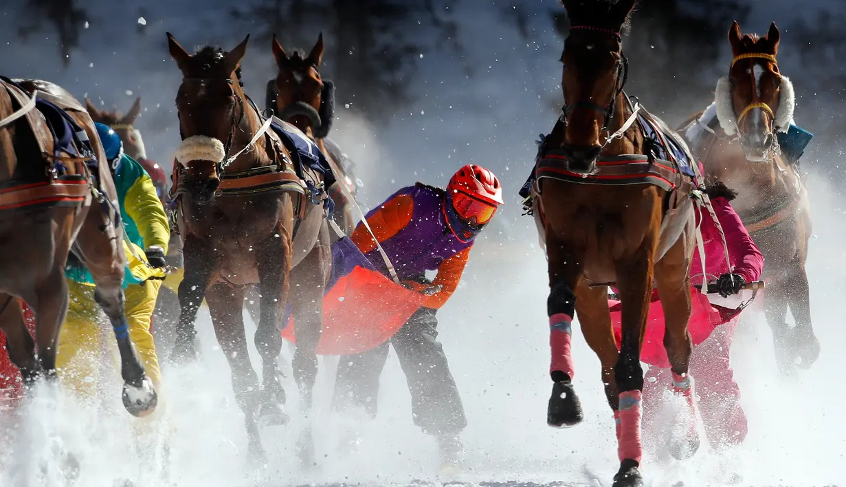 Para peserta ditarik oleh kuda mereka saat lomba Skijoring selama pacuan kuda White Turf di danau beku, Saint Moritz, Swiss, 17 Februari 2019. Skijoring mengharuskan kuda-kuda peserta menarik pemain ski di atas lintasan. (STEFAN WERMUTH / AFP)