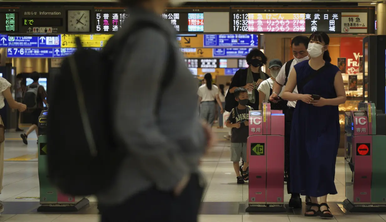 Orang-orang yang memakai masker untuk membantu mengekang penyebaran virus corona COVID-19 berjalan di sekitar stasiun kereta api di Tokyo, Jepang, Jumat (6/8/2021). Tokyo berada dalam keadaan darurat virus corona COVID-19 sejak pertengahan Juli. (AP Photo/Kantaro Komiya)