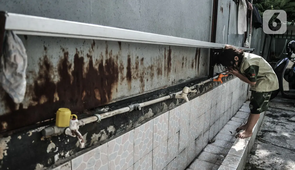 Seorang anak korban kebakaran saat menggunakan air di gedung SMP PGRI 32, Cideng, Jakarta, Minggu (8/11/2020). Sebanyak 81 warga terpaksa mengungsi di gedung sekolah usai permukiman mereka di RT 4 RW 7 Kelurahan Cideng ludes dilalap api pada Sabtu (7/11). (merdeka.com/Iqbal Septian Nugroho)