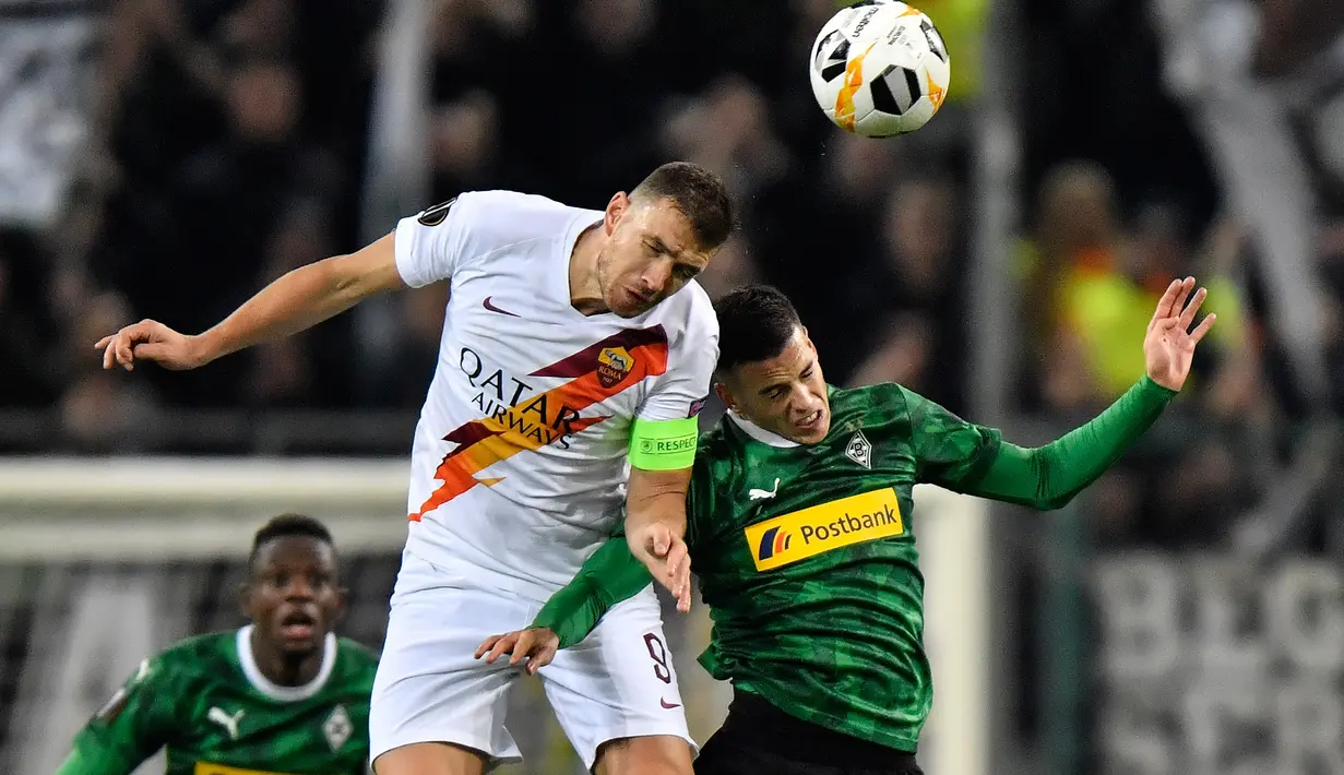 Pemain Borussia Monchengladbach, Laszlo Benes berebut bola dengan Striker AS Roma, Edin Dzeko dalam laga matchday keempat fase grup Liga Europa 2019-2020 di Stadion IM Borussia-Park, Kamis (7/11/2019). AS Roma takluk dari tim tuan rumah dengan skor 2-1. (AP/Martin Meissner)