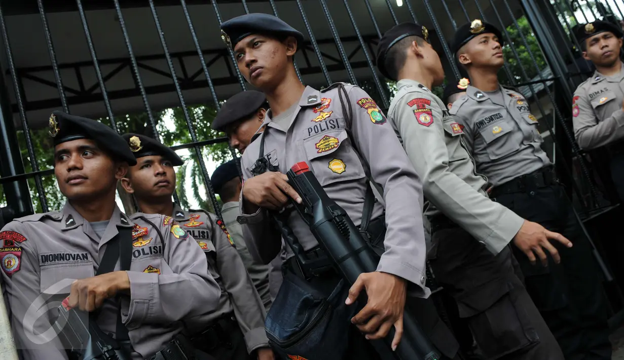 Petugas polisi membawa senapan gas air mata saat berjaga di depan Gedung Kementerian Pertanian, Jakarta, Selasa (3/1). Sedikitnya 2.500 personel kepolisian mengamankan sidang lanjutan Basuki Tjahaja Purnama (Ahok). (Liputan6.com/Helmi Afandi)