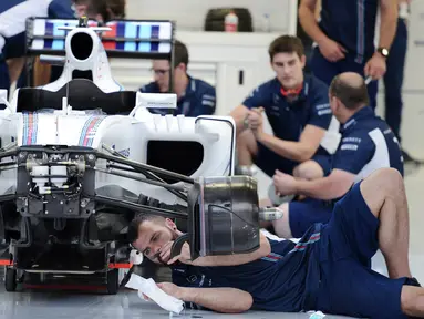 Tim Williams Martini Racing merakit mobil Formula 1 di Sirkuit Sakhir, Bahrain (31/3). jelang Grand Prix F1 Bahrain, Sejumlah tim sibuk mempersiapkan mobil terbaiknya masing-masing. (AFP PHOTO/MOHAMMED AL-SHAIKH)