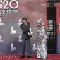 Presiden Indonesia Joko Widodo atau Jokowi menyapa Direktur Jenderal Organisasi Perdagangan Dunia (WTO) Ngozi Okonjo-Iweala saat tiba pada hari pertama Konferensi Tingkat Tinggi (KTT) G20 di Nusa Dua, Bali, Selasa (15/11/2022) pagi. Jokowi menyampaikan ucapan selamat datang di lobi depan venue utama KTT G20. (Mast Irham/Pool Photo via AP)