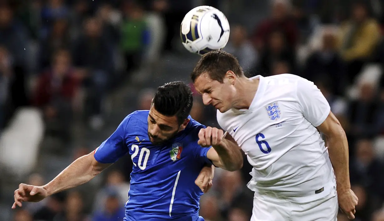 Penyerang Italia, Graziano Pelle berebut bola udara dengan bek Inggris Phil Jagielka saat laga persahabatan di Juventus Stadium,Italia, Rabu (1/4/2015). Italia bermain imbang 1-1 atas Inggris. (REUTERS/Giorgio Perottino)