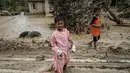 Sementara, Desa Babo merupakan sebuah kampung yang terletak di Kecamatan Bandar Pusaka, Kabupaten Aceh Tamiang, Provinsi Aceh. Tampak dalam foto, seorang anak laki-laki mengenakan pakaian sumbangan berjalan di sepanjang jalan berlumpur di Babo, Aceh Tamiang, pada Senin 15 Desember 2025. (Yasuyoshi CHIBA/AFP)