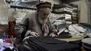Perajin menyelesaikan pembuatan topi tradisional di sebuah bengkel kerja di Peshawar, Pakistan barat laut, pada 28 Desember 2020. Topi tradisional yang terbuat dari bahan wol ini sangat populer di kalangan warga Pakistan selama musim dingin. (Xinhua/Saeed Ahmad)