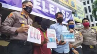 Tersangka pengedar uang palsu di Polsek Pekanbaru Kota bersama barang bukti kejahatannya. (Liputan6.com/M Syukur)