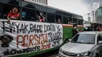 Suporter Persija berada di dalam bus melewati jalan Gatot Subroto menuju stadion Gelora Bung Karno, Jakarta, Minggu (9/12). Antusiasme ribuan suporter Persija bersiap mendukung tim kesayangannya bertanding melawan Mitra Kukar. (Liputan6.com/Faizal Fanani)