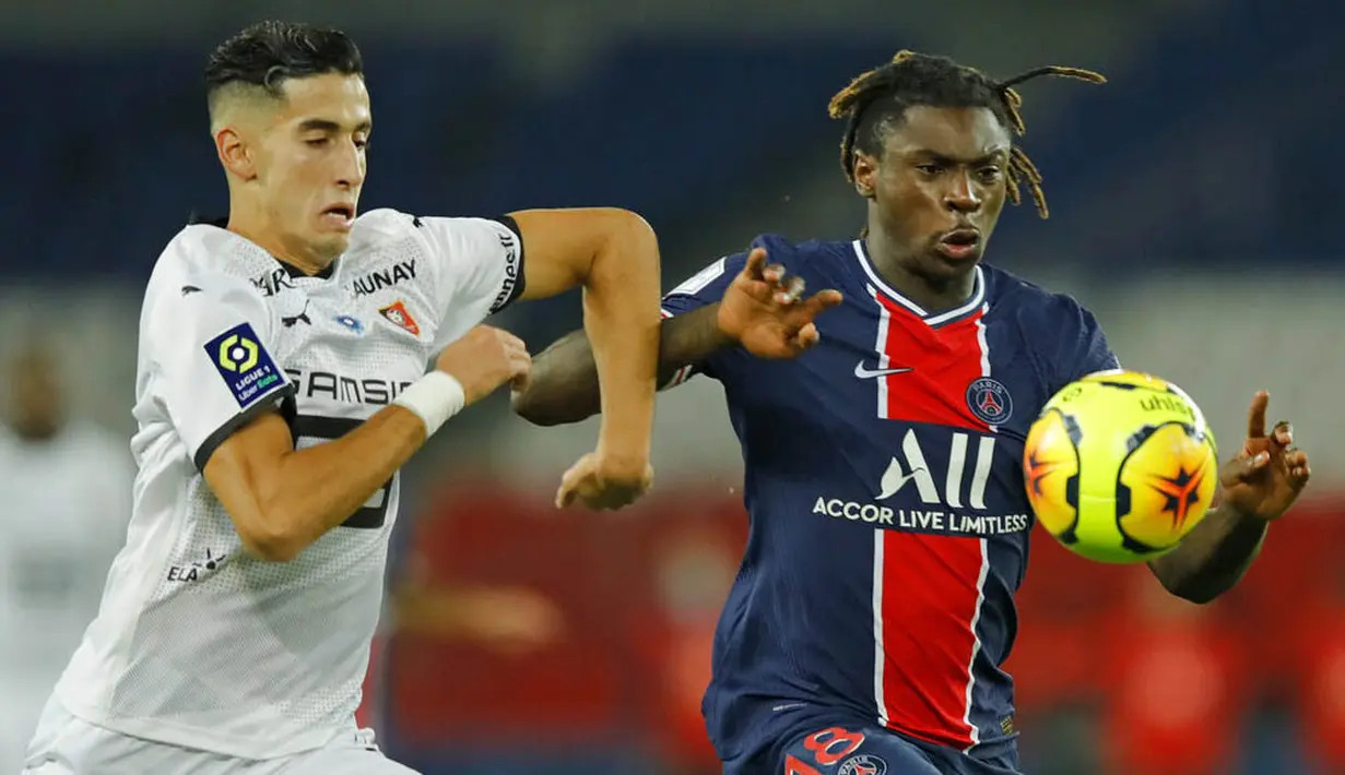 Penyerang Paris Saint-Germain (PSG), Moise Kean, berebut bola dengan pemain Renners, Nayef Aguerd, pada laga Liga Prancis di Stadion Parc des Princes, Sabtu (7/11/2020). PSG menang dengan skor 3-0. (AP/Christophe Ena)