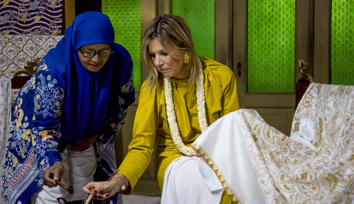 Ratu Maxima dari Belanda (kanan), dalam kapasitasnya sebagai Advokat Khusus Sekretaris Jenderal PBB untuk Keuangan Inklusif untuk Pembangunan (UNSGSA), mencoba membatik di Kampung Batik Laweyan, Surakarta, Jawa Tengah, pada Selasa 25 November 2025. Ratu Belanda, Maxima Zorreguieta Cerruti, mengunjungi Kampung Batik Laweyan, Surakarta, Jawa Tengah, Selasa (25/11/2025). (DEVI RAHMAN/AFP)
