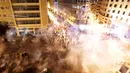 Pengunjuk rasa berlarian saat polisi menembakkan gas air mata untuk membubarkan massa selama protes menentang rencana pengenaan pajak baru di Beirut, Lebanon, Jumat (18/10/2019). Saat ini Lebanon menjadi salah satu negara dengan utang terbesar di dunia. (AP Photo/Hassan Ammar)