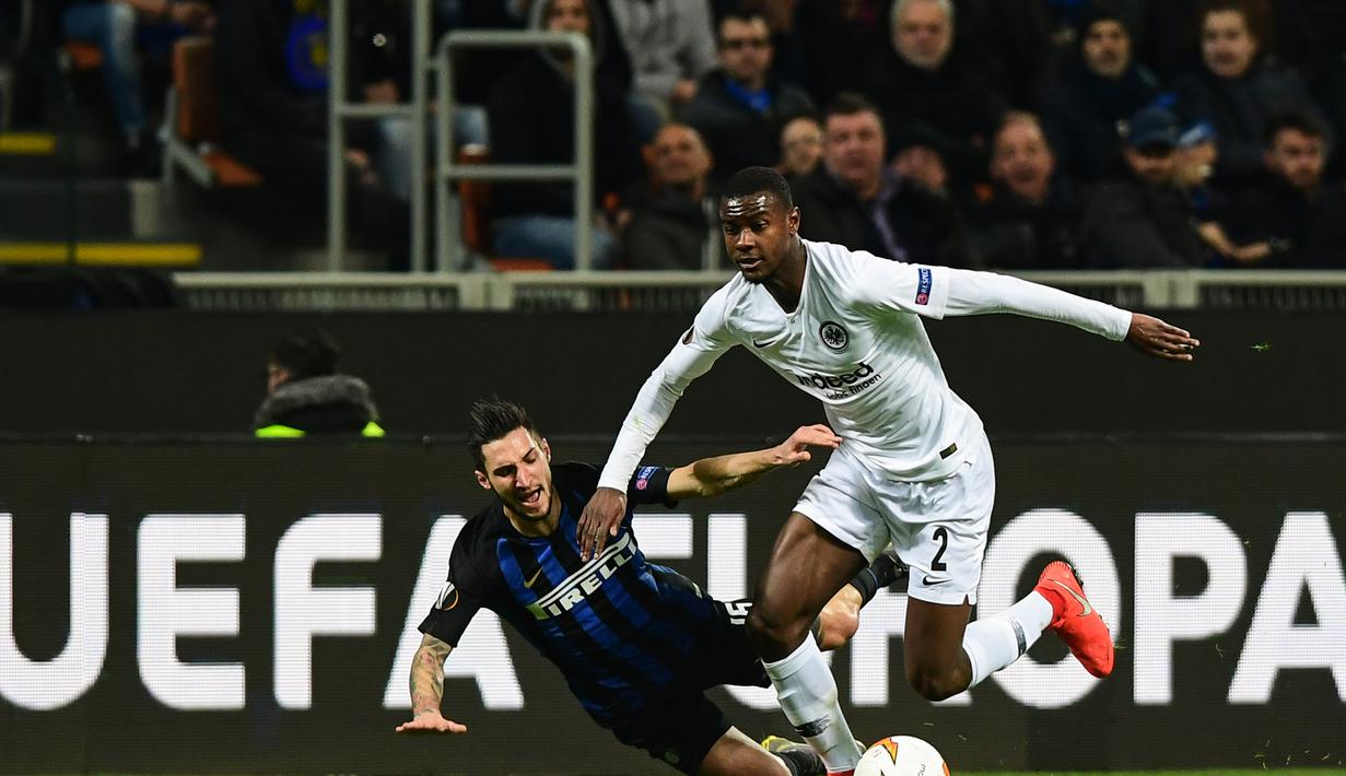 Matteo Politano gagal menghentikan Obie Ndicka pada leg kedua, babak 16 besar Liga Europa yang berlangsung di Stadion Giuseppe Meazza, Jumat (15/3). Inter Milan kalah 0-1 kontra Eintracht Frankfurt. (AFP/Miguel Medina)