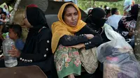 Wanita Rohingya duduk di tempat penampungan darurat di Ghumdhum, Cox's Bazar, Bangladesh, (27/8). Bentrokan tersebut mengakibatkan 92 orang tewas, termasuk 12 tentara. (AP Photo / Mushfiqul Alam)