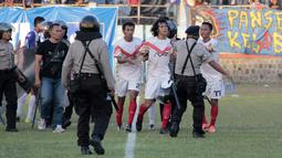 Pemain Persis Solo, Rico Fernanda diamankan petugas setelah terlibat keributan dalam final lanjutan Piala Polda Jateng di Stadion Jatidiri, Semarang, Minggu (2/8/2015). (Bola.com/Vincensius Sawarno)