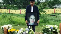 Husni Fadhil berdiri di samping makam kekasihnya yang merupakan pramugari Lion Air JT 610. (dok. Instagram @apryfadhil/https://www.instagram.com/p/Bp9KPn6gIIv/?utm_source=ig_web_copy_link/Asnida Riani)