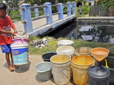 Seorang anak membawa ember saat mengambil air bersih di kawasan Karangbahagia, Kabupaten Bekasi, Jawa Barat, Selasa (7/9/2021). Pemerintah Kabupaten Bekasi mendistribusikan air bersih kepada warga yang tinggal di pinggiran Kali Cilemahabang. (Liputan6.com/Herman Zakharia)