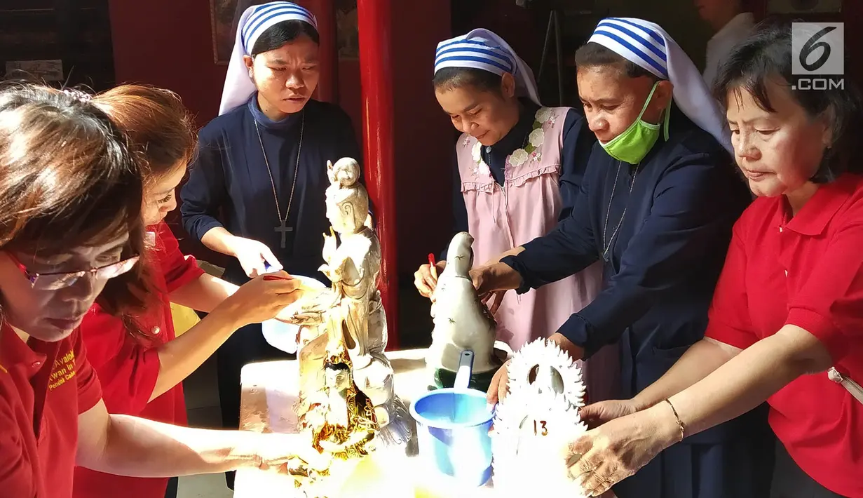 Suster Katolik dan pengurus vihara membersihkan patung dewa dewi di Vihara Kwan In Thang, Pondok Cabe, Tangerang Selatan, Rabu (30/1). Dalam pembersihan itu melibatkan umat agama lain sebagai bentuk toleransi kerukunan beragama. (Merdeka.com/Arie Basuki)