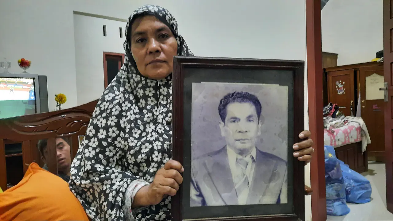 Cut Badriah (57) memegang foto TM. Syah Husin, ayahnya. Foto diambil berselang beberapa hari setelah rumah perempuan itu digusur oleh Kodam IM (Liputan6.com/Rino Abonita)