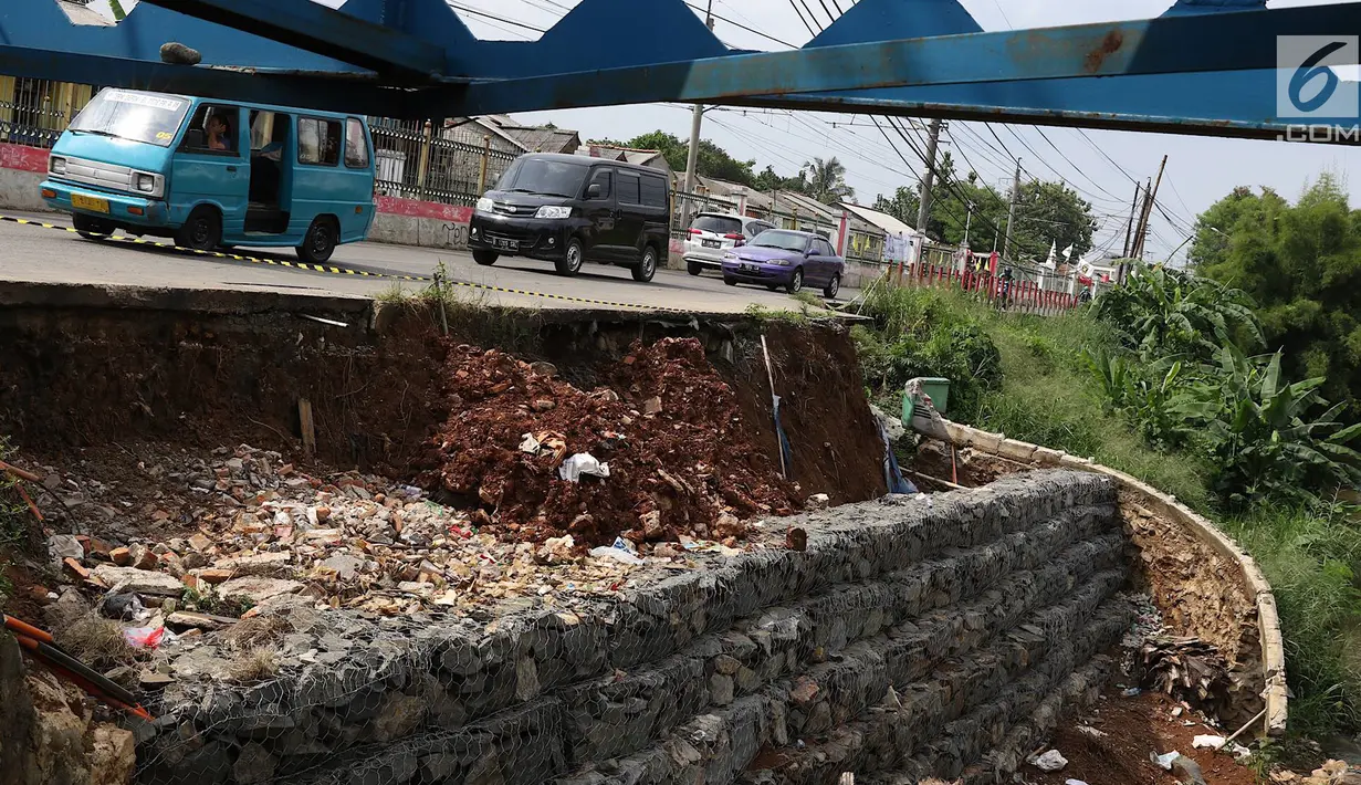 Kendaraan melintas di samping Jalan Raya Citayam yang amblas di kawasan Cipayung, Depok, Jawa Barat, Rabu (27/2). Kondisi tepi jalan yang tidak kunjung diperbaiki membahayakan pengguna jalan terutama saat malam hari. (Liputan6.com/Immanuel Antonius)