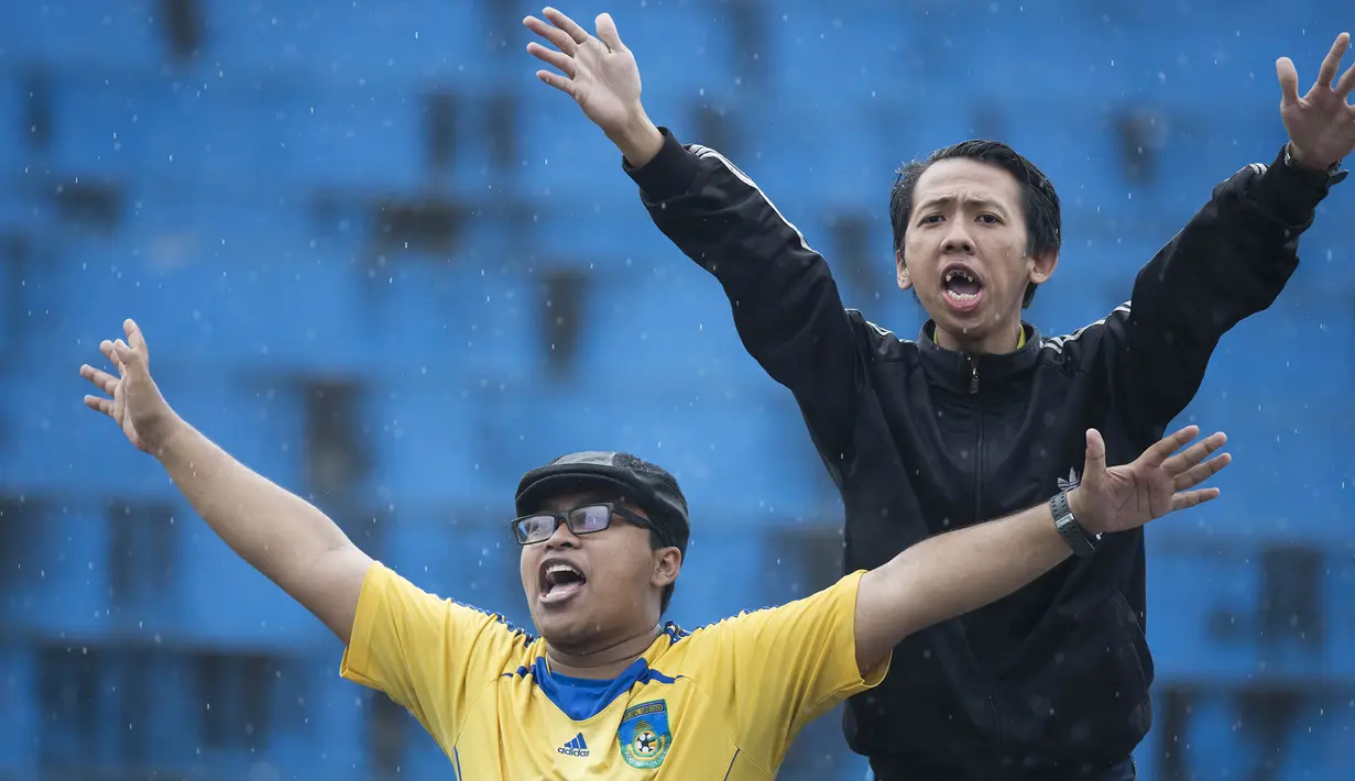 Dua orang pendukung Gresik United bernyanyi saat laga melawan Sriwijaya FC pada Piala Jenderal Sudirman di Stadion Kanjuruhan, Malang, Kamis (19/11/2015). (Bola.com/Vitalis Yogi Trisna)