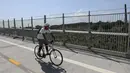 Pengendara sepeda melintasi jembatan di dekat sebuah taman pemakaman di New York, Amerika Serikat (AS) (29/7/2020). Kematian akibat COVID-19 di AS telah menembus angka 150.000 pada Rabu (29/7), tepatnya 150.034 hingga pukul 15.35 waktu setempat atau Kamis (30/7) pukul 02.35 WIB. (Xinhua/Wang Ying)