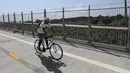 Pengendara sepeda melintasi jembatan di dekat sebuah taman pemakaman di New York, Amerika Serikat (AS) (29/7/2020). Kematian akibat COVID-19 di AS telah menembus angka 150.000 pada Rabu (29/7), tepatnya 150.034 hingga pukul 15.35 waktu setempat atau Kamis (30/7) pukul 02.35 WIB. (Xinhua/Wang Ying)
