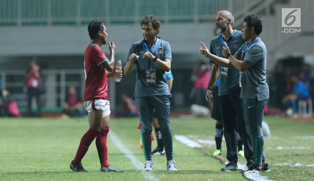 Pelatih Indonesia U-23, Luis Milla (kedua kiri) memberi arahan pada M Hargianto saat melawan Bahrain pada laga PSSI Anniversary 2018 di Stadion Pakansari, Kab Bogor, Jumat (27/4). Babak pertama Indonesia tertinggal 0-1. (Liputan6.com/Helmi Fithriansyah)