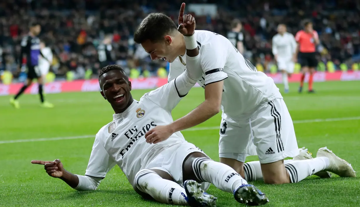 Striker Real Madrid, Vinicius Junior (kiri) berselebrasi setelah mencetak gol ke gawang Leganes pada laga leg pertama babak 16 besar Copa del Rey di Santiago Bernabeu, Rabu (9/1). Real Madrid sukses mengandaskan Leganes dengan skor 3-0 (AP/Manu Fernandez)