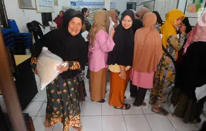 Keluarga penerima manfaat (KPM) membawa bantuan sosial pangan beras saat berlangsung penyaluran di kantor Kelurahan Meruyung, Depok, Sabtu  (11/5/2024). (merdeka.com/Arie Basuki)