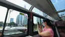 Seorang wanita mengambil foto di dalam sebuah bus wisata di Shenzhen, Provinsi Guangdong, China (22/10/2020). Shenzhen pada Kamis (22/10) meluncurkan tiga jalur bus wisata bagi wisatawan, yang masing-masing menampilkan budaya, teknologi, dan pemandangan malam kota tersebut. (Xinhua/Mao Siqian)