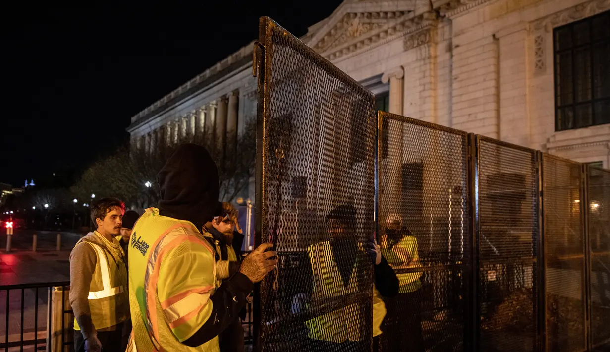 Pekerja memasang pagar besi di pintu masuk Gedung Putih mengantisipasi kerusuhan menjelang Pilpres Amerika Serikat di Washington DC, Senin (2/11/2020). Sebagai persiapan kemungkinan ada aksi terorisme atau protes massa, Gedung Putih membangun pagar baru. (Chris McGrath/Getty Images/AFP)